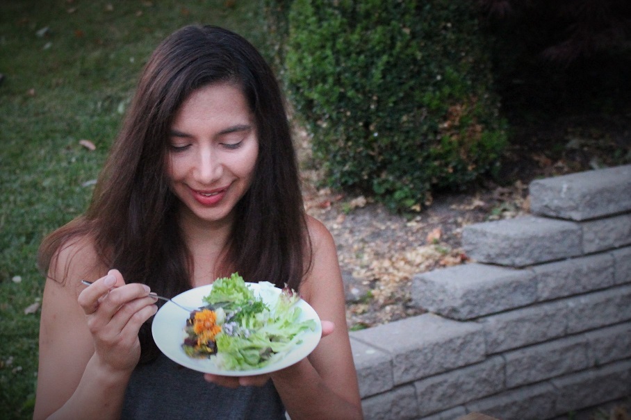 Jennifer Heard PhD-DNM, E-RYT enjoying an organic spring salad with wild flowers
